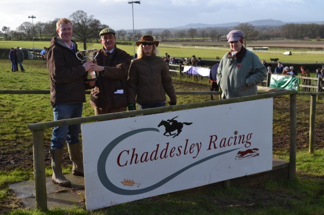 Bruce Cook picks up the trophy after the race