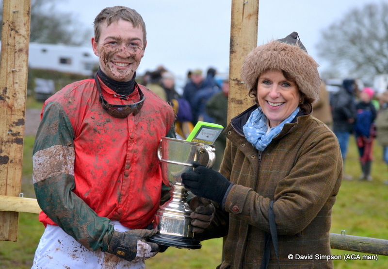 A muddy Fred Timmis receives his trophy from Caroline Robinson after winning the PPORA Club Members race for Novice Riders